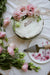 A birthday cake with flowers and a serving plate.